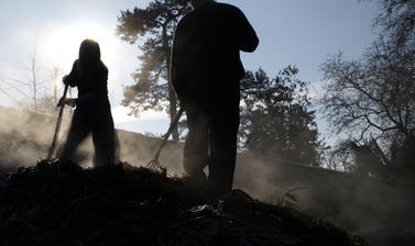 staff turning compost