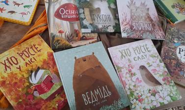A selection of Ukrainian-language children's books laid out on a table. Most of the books show cute and colourful illustrations of woodland creatures on the cover. 